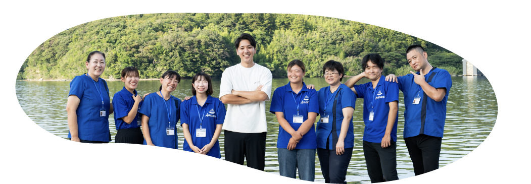 水辺を背景にしたAmacareチームの集合写真